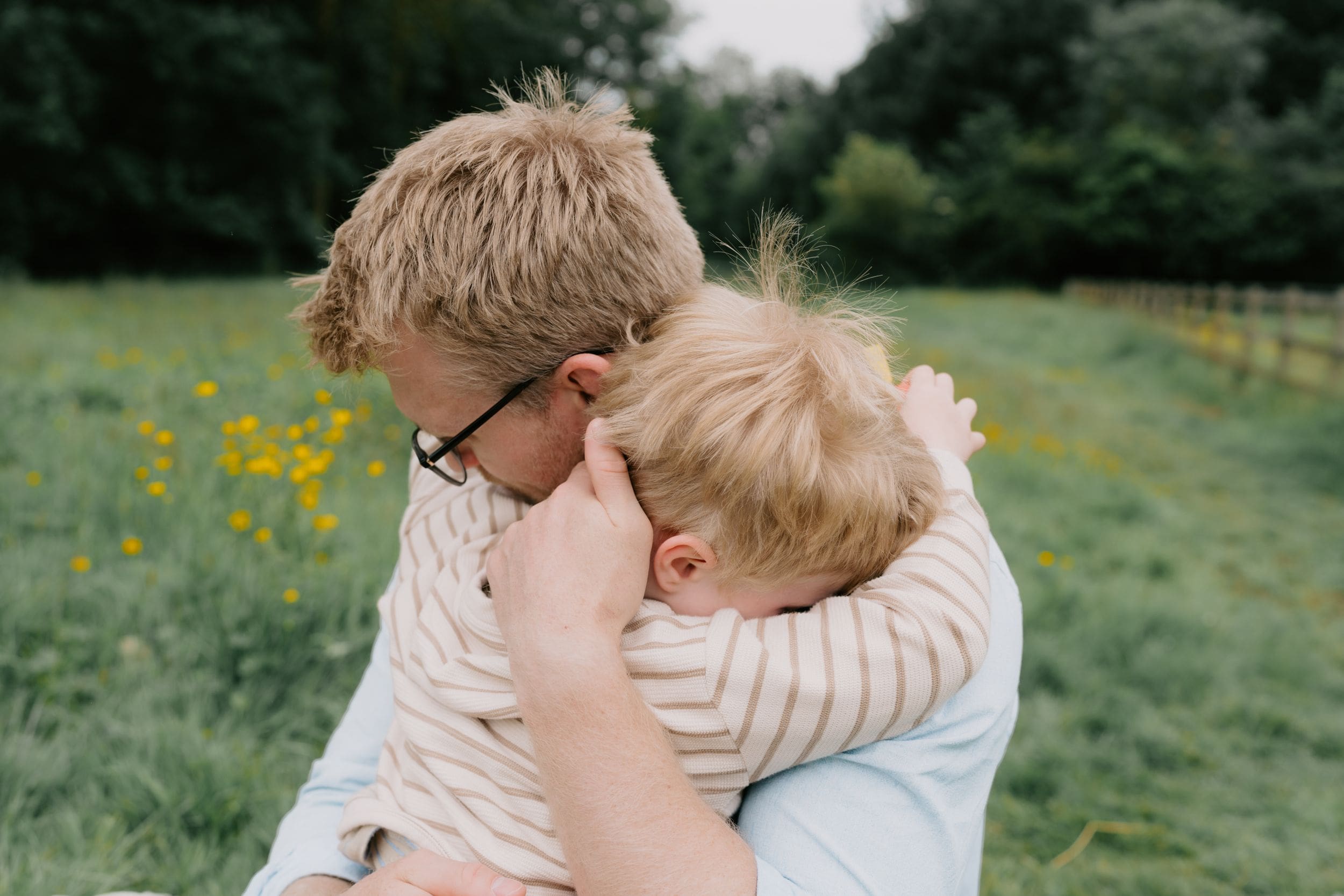 A father and son embracing during a family photoshoot by Ipswich family photographer. Keeping the kids happy.